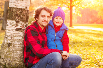 Father walks with his son in the autumn park. A child and a man in the forest are having fun on a walk. Family spends time in nature