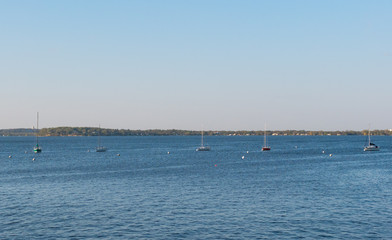 MADISON, WISCONSIN - MAY 07, 2018: Sailboats anchored in a line on Lake Mendota.