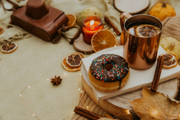 Cozy autumn composition with hot tea, donut and fall decorations