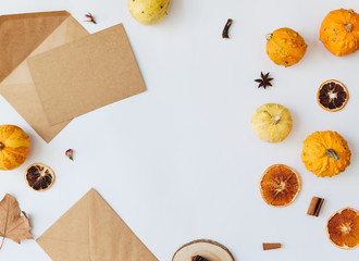 Flat lay style of autumn and thanksgiving concept with  pumpkins. Greeting card. Craft envelope with decorations on white background. Top view