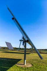 Solaranlage, Solarkraftwerk mit nachführbaren Elementen bei Sonnenschein Seitenansicht mit...