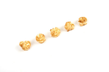 A few pieces caramel popcorn on white background.