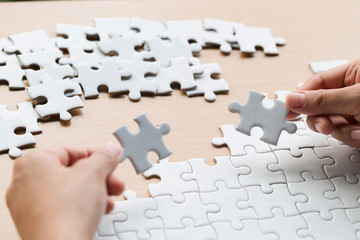 Close up of hands business women connecting jigsaw puzzleon, Teamwork workplace success and strategy concept.