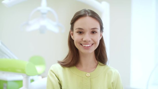 Portrait of happy dentist in dental clinic. Smiling stomatologist in dental office. Medical student in dentist office. Close up of woman dentist looking at camera