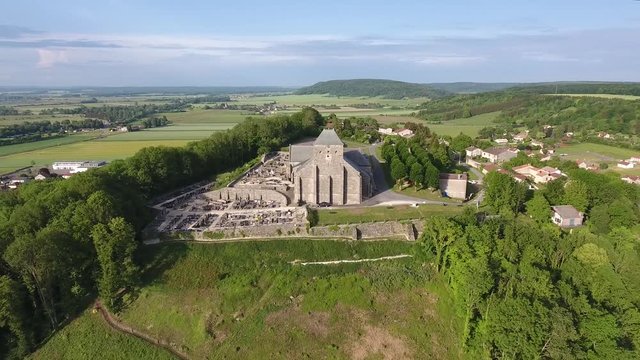 View of a church on a hill in Dun sur Meuse France. From close to far by drone