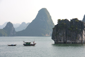 Fototapeta na wymiar Pequeña embarcación cruzando la bahía de Ha Long, Vietnam