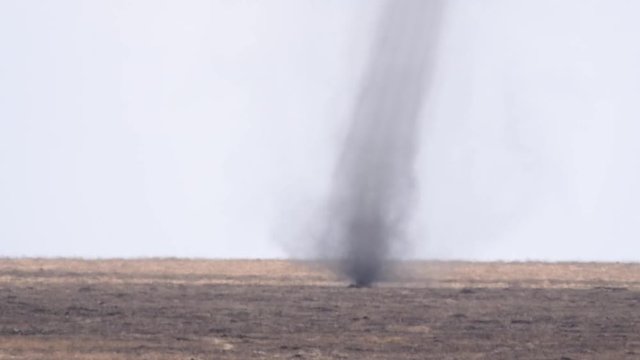 A dust devil swirling across dry open savannah, Masai Mara, Kenya