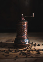 Vintage copper pepper mill on wooden background
