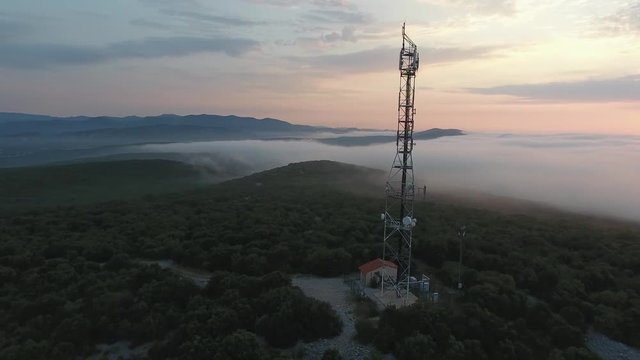 Drone shot turning around a big antenna in South of France, during sunrise. Medium altitude 