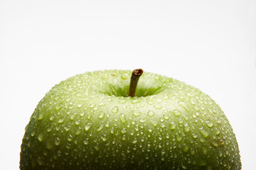 FRESH GREEN APPLE COVERED IN WATER DROPLETS ON WHITE BACKGROUND