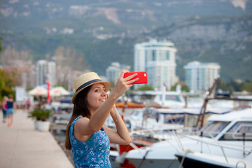 Fototapeta premium Europe travel selfie, cute happy smiling tourist girl taking self-portrait picture with smartphone during summer vacation in famous European Mediterranean destination.