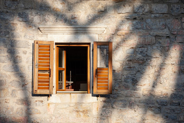 Brown window shutters on old wall of Mediterranean city.