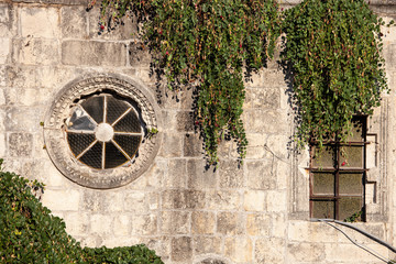Round vintage window on old wall of Mediterranean city.