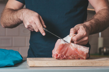 A man is engaged in cooking meat, cooking at home