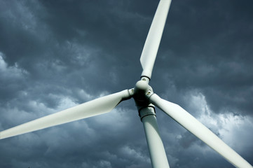 WIND TURBINE AGAINST STORMY BLUE SKY