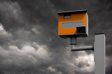 YELLOW GATSO ROAD SAFETY SPEED CAMERA AGAINST STORMY GREY SKY