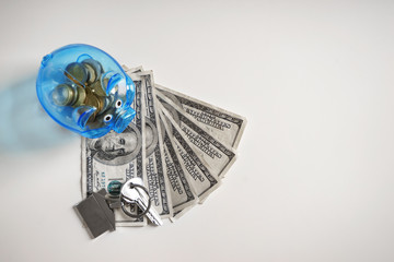 Piggy bank, money and keys on white background. Concept of saving money for buying new house
