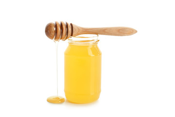 Jar of honey with dipper on white background