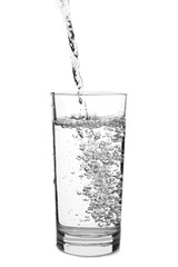 Pouring of water in glass on white background