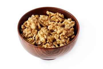 Walnut kernels in wooden bowl isolated on white background