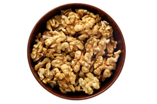 Walnut kernels in wooden bowl isolated on white background
