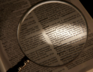 MAGNIFYING GLASS ON DICTIONARY PAGE SHOWING DEFINITION OF THE WORD AGREEMENT