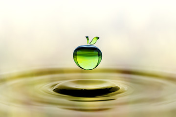 Falling water drop in green apple shape - Powered by Adobe