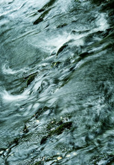 Powerful flow of water over the stones, close-up