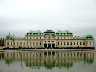 Fototapeta na wymiar Belvedere Palace reflected in the water in a foggy day, Vienna, Austria
