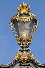 Fototapeta na wymiar ancient lantern with golden crown at fence