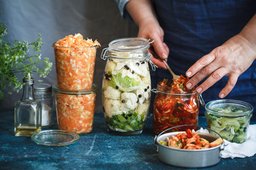Fermented preserved vegetarian food concept. Cabbage kimchi, broccoli marinated, sauerkraut sour glass jars