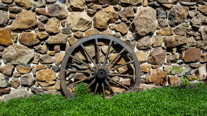 Cart Wheel Against Old Rock Cabin