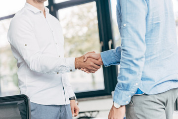 Obraz premium cropped shot of businessmen shaking hands in office