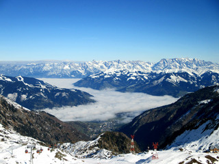 Beautiful landscape of snowy mountains in a foggy valley in Zell am See, Austria