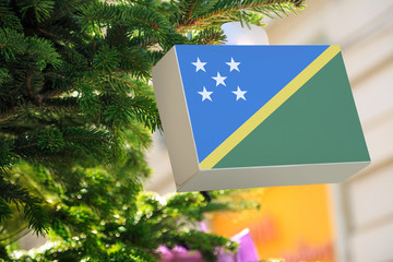 Solomon Islands flag printed on a Christmas gift box. Printed present box decorations on a Xmas...