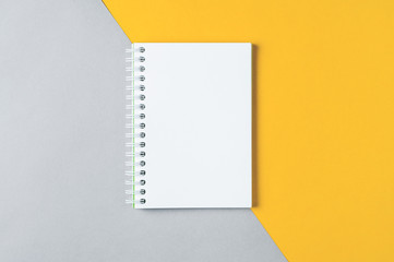 White notebook on grey-yellow background