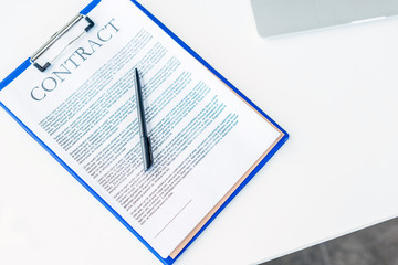 top view of business contract with pen on white table