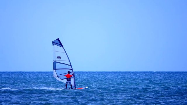 Windsurfer silhouette over sea