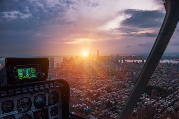 Aerial view from the helicopter cabin on the evening city of New York. The last rays of the setting sun illuminate the city.   © Ann Stryzhekin