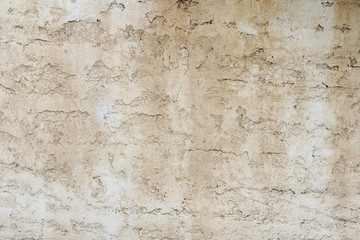 Old concrete light brown wall with rough texture. Outdoor texture.