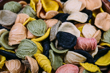 Traditional Italian Rainbow pasta. Colored raw pasta on a stone background