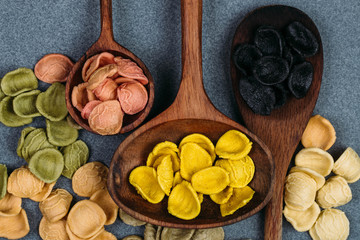 Traditional Italian Rainbow pasta. Colored raw pasta on a stone background