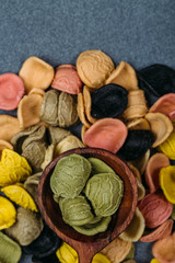 Traditional Italian Rainbow pasta. Colored raw pasta on a stone background