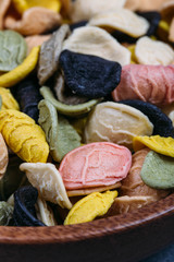 Traditional Italian Rainbow pasta. Colored raw pasta on a stone background