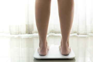 young woman standing on digital weight scale