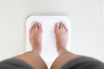 young woman standing on digital weight scale