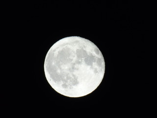 An amazing caption of the full moonlight over the city by night in summer days with some clouds and foggy