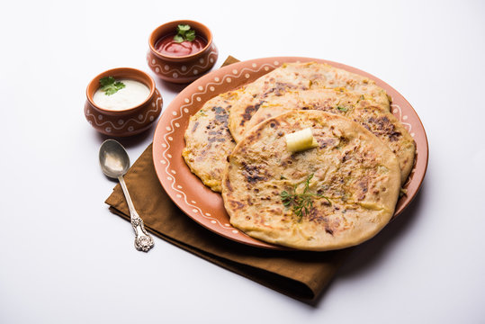 Aloo Paratha / Indian Potato stuffed Flatbread. Served with fresh curd and tomato ketchup. selective focus