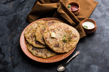 Aloo Paratha / Indian Potato stuffed Flatbread. Served with fresh curd and tomato ketchup. selective focus