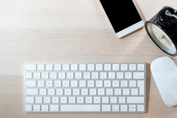 office table with computer keyboard, mouse, smartphone and alarm clock. topview, copy space